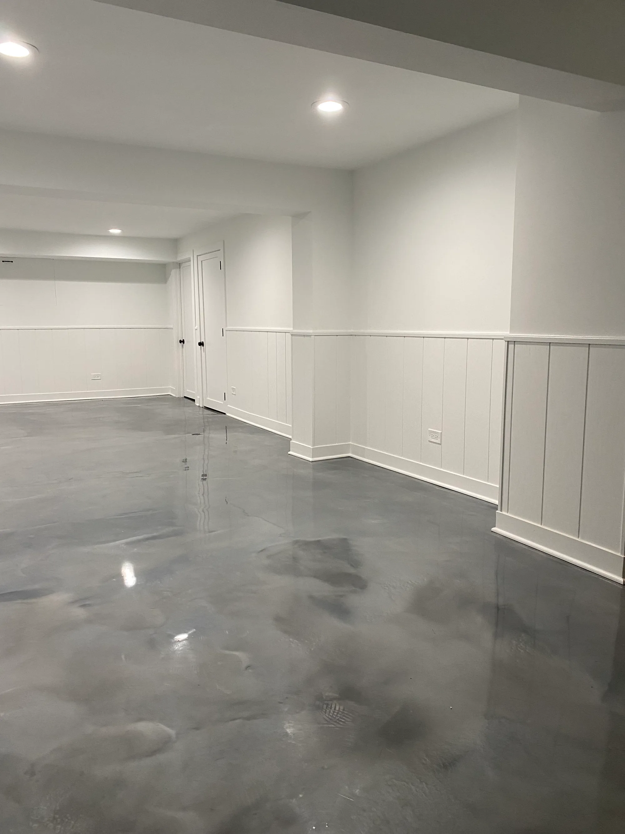 Glenview basement by Delta: contemporary open layout with polished concrete metallic-finish floor, white walls, board-and-batten wainscoting