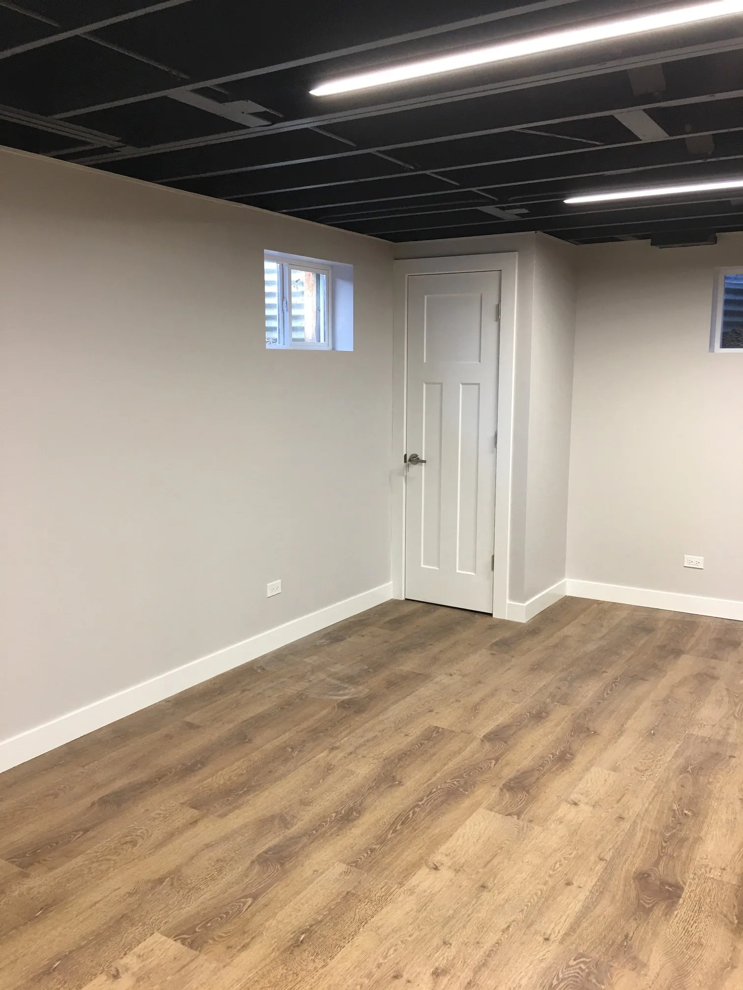 Lake Forest basement: refinished oak staircase descending into open-ceiling lower level
