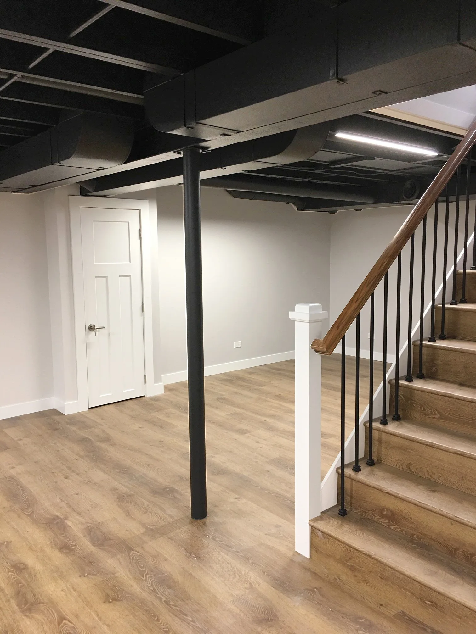 Lake Forest basement: industrial-style exposed ductwork painted matte black