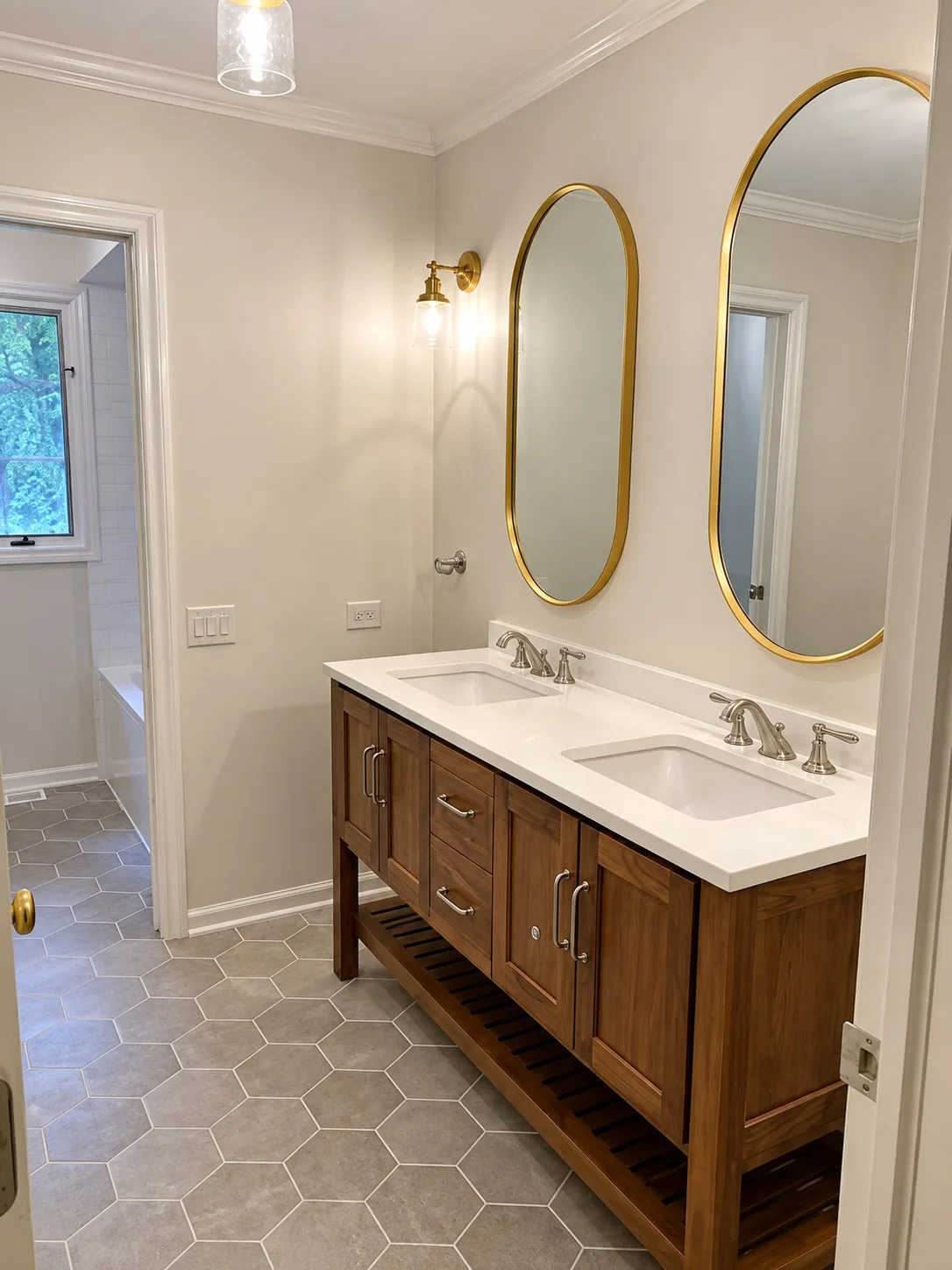 Libertyville bathroom remodel with a custom wood double vanity, gold-framed oval mirrors and gray hex tile floor
