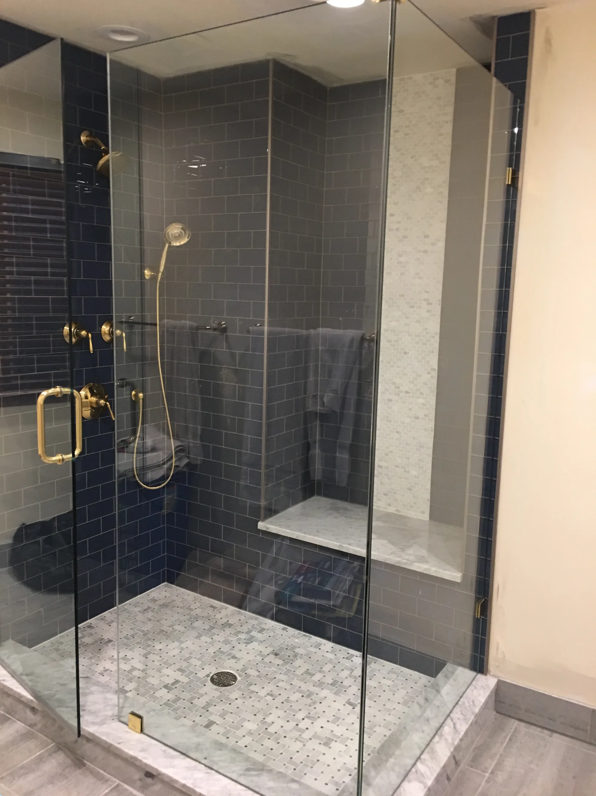 Lake Forest bathroom: gray double vanity with carrara marble counters and glass-front center tower