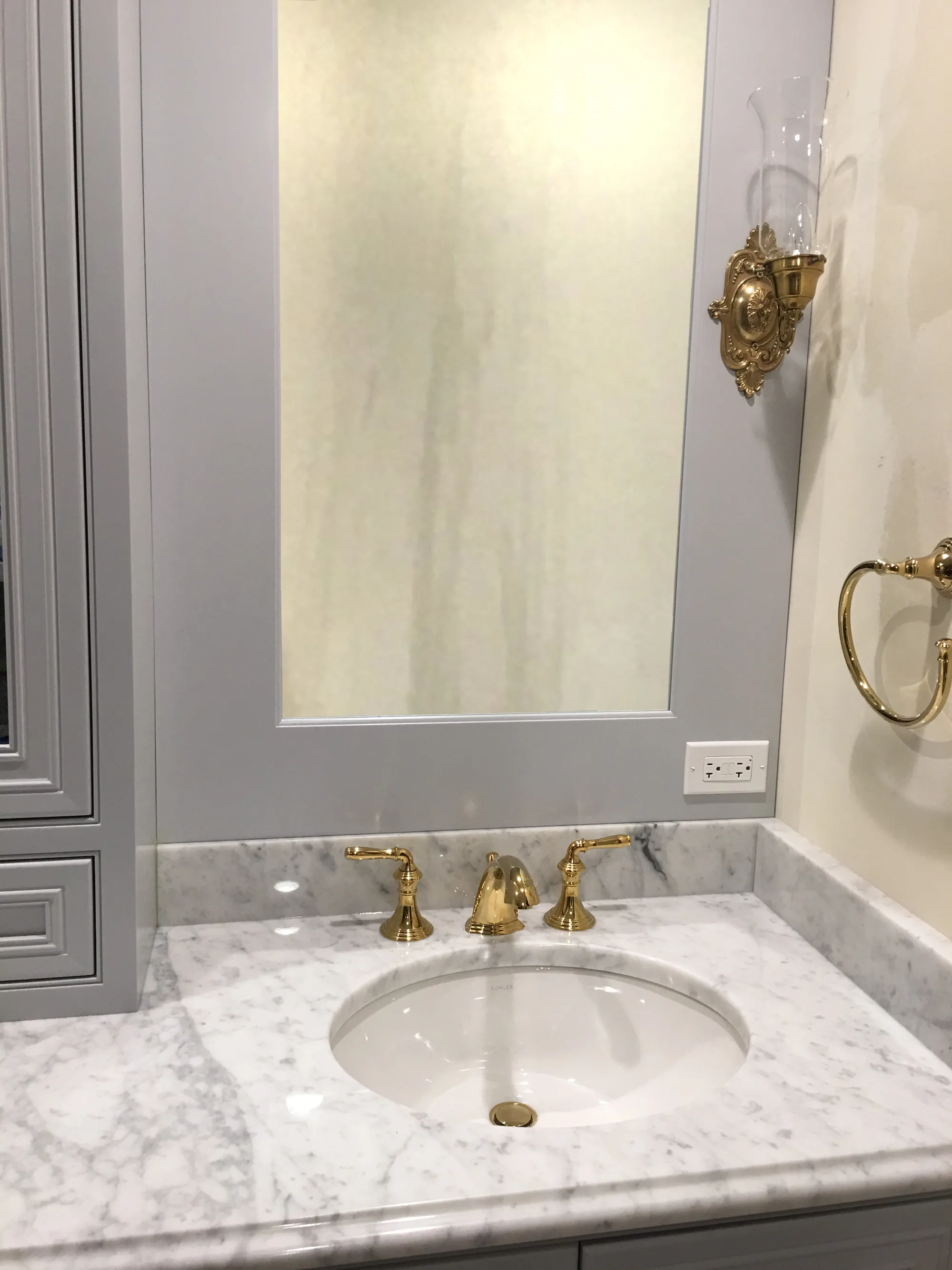 Lake Forest bathroom: polished brass widespread faucet over carrara marble counter and undermount sink