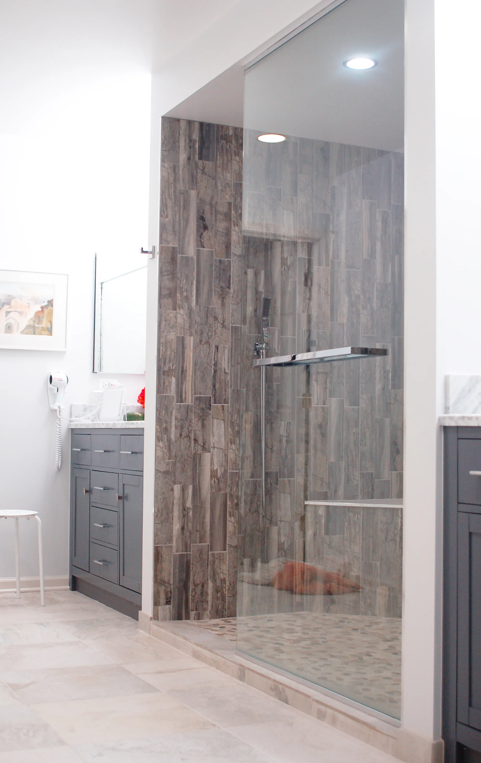Northbrook bathroom by Delta: driftwood-look gray plank tile shower feature wall, gray shaker vanity, carrara marble counter, hex marble floor