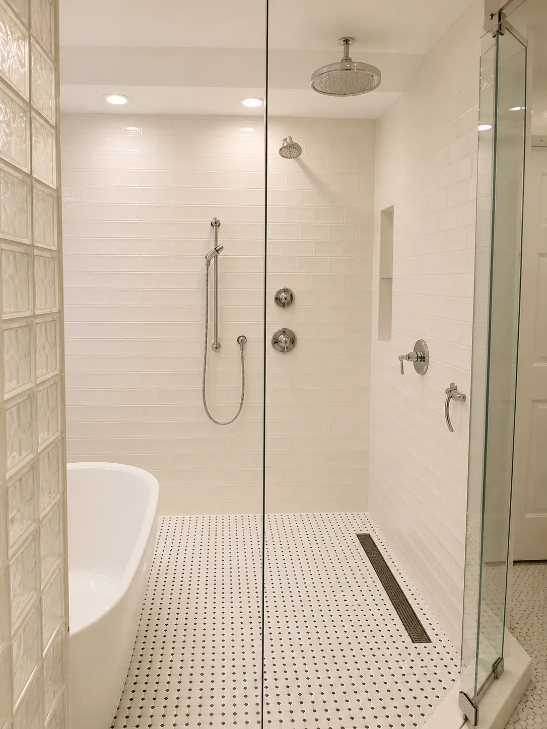 Glass-enclosed wet room with a rain shower and freestanding tub in the completed Lake Bluff remodel