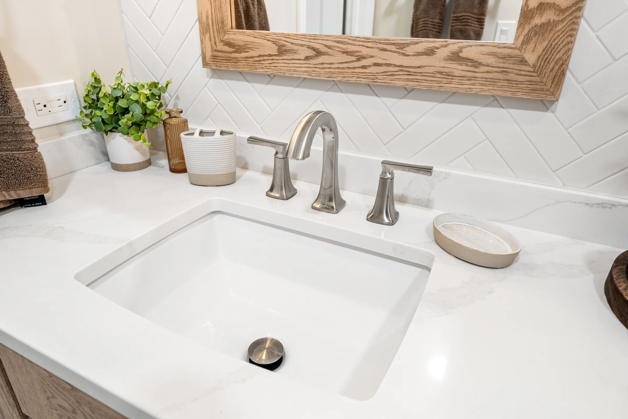 Lake Zurich bathroom remodel: wood-framed mirrors and pendant lighting over oak vanity