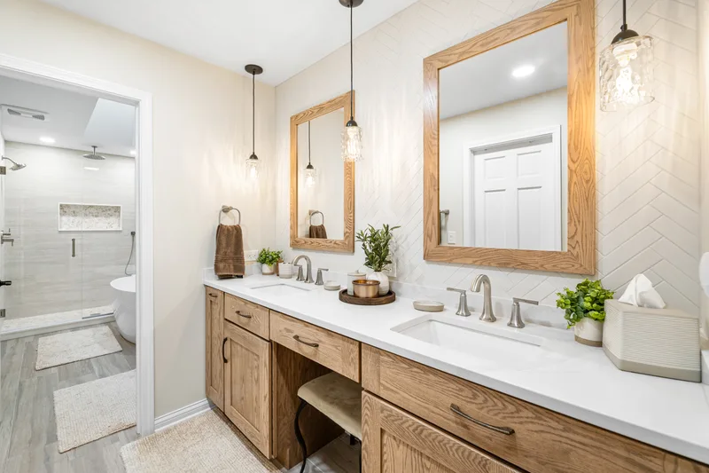 Lake Zurich primary bathroom with warm oak vanity and herringbone tile shower