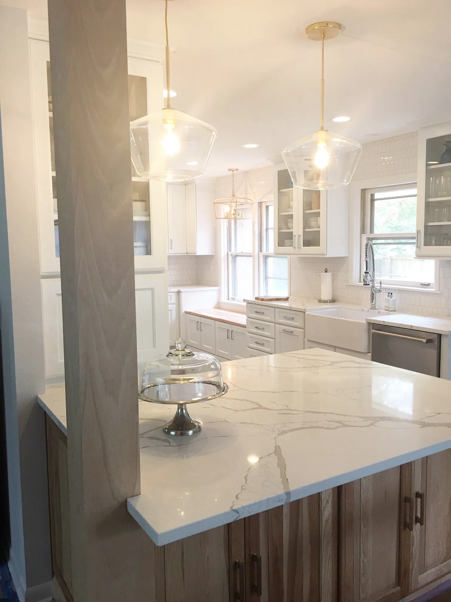 Lake Bluff kitchen: oak-base island with calacatta quartz waterfall counter and glass globe pendant
