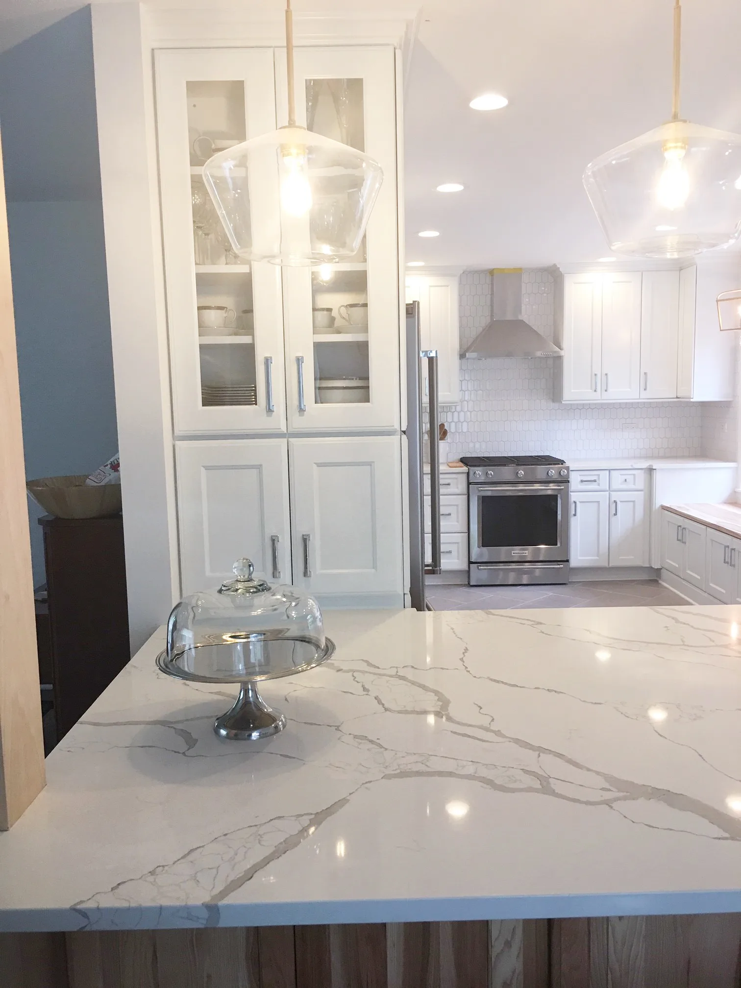 Lake Bluff kitchen: hexagonal mosaic tile backsplash and glass-front upper cabinetry