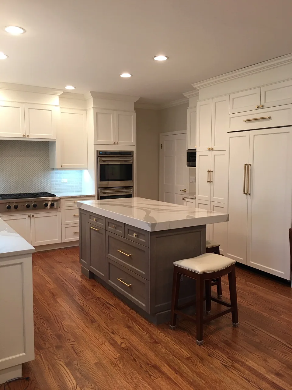 Lake Forest kitchen: white shaker perimeter cabinetry with brushed brass hardware and white subway tile backsplash
