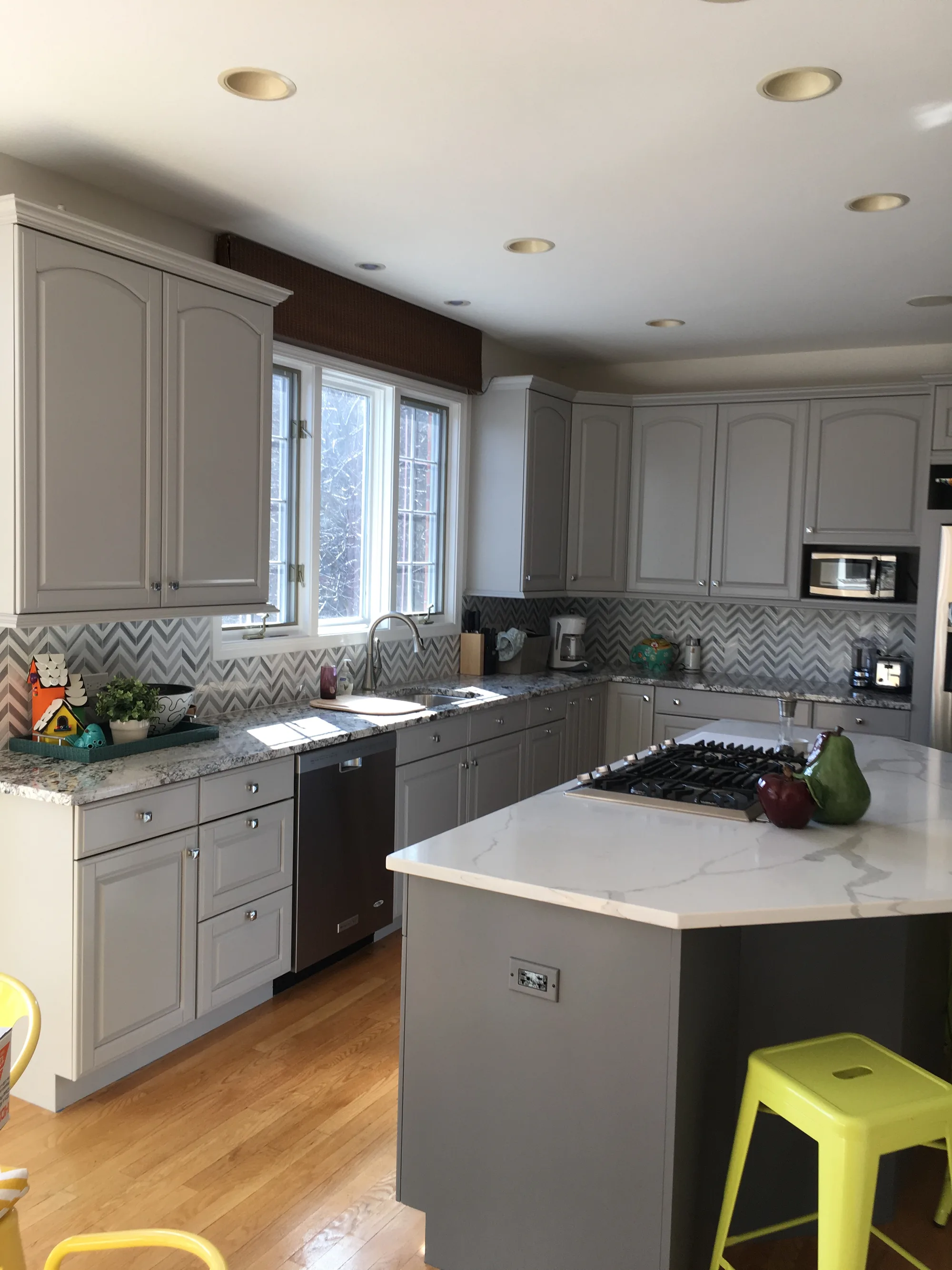 Northbrook kitchen by Delta: gray cathedral-arch cabinetry, chevron mosaic backsplash, calacatta quartz counters, stainless gas cooktop
