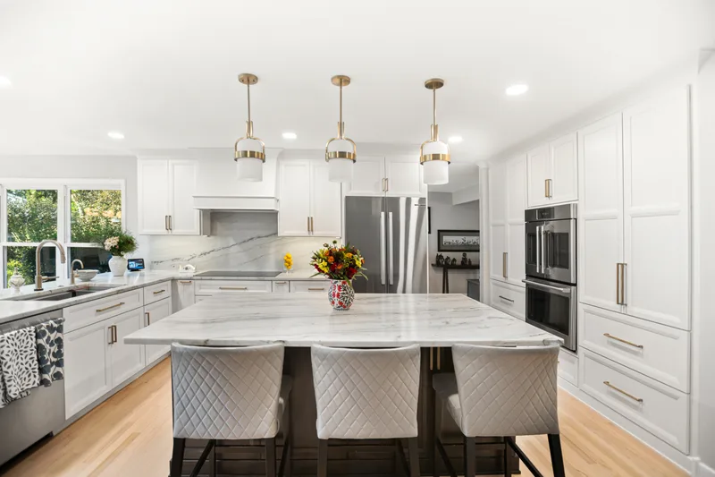 Glenview kitchen remodel: white shaker cabinetry with marble island and brass pendants