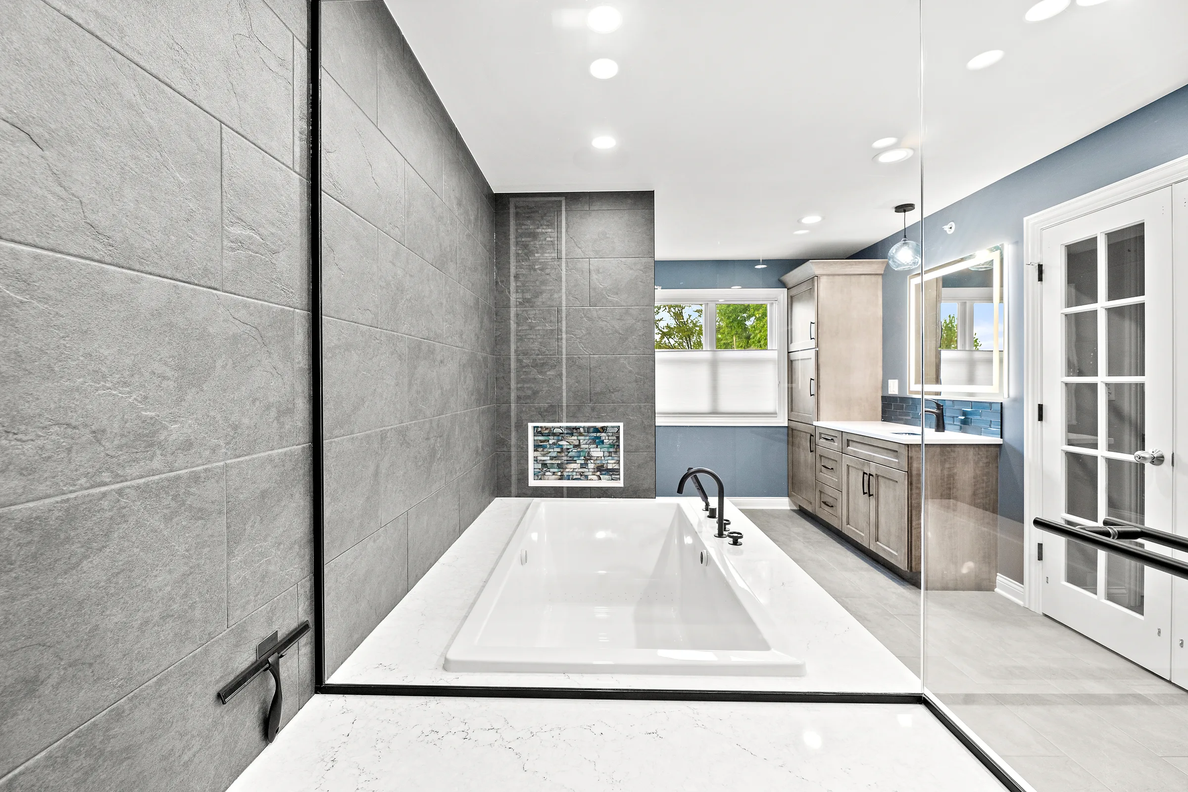Mount Prospect spa bathroom: large-format slate tile with drop-in soaking tub and glass mosaic accent niche
