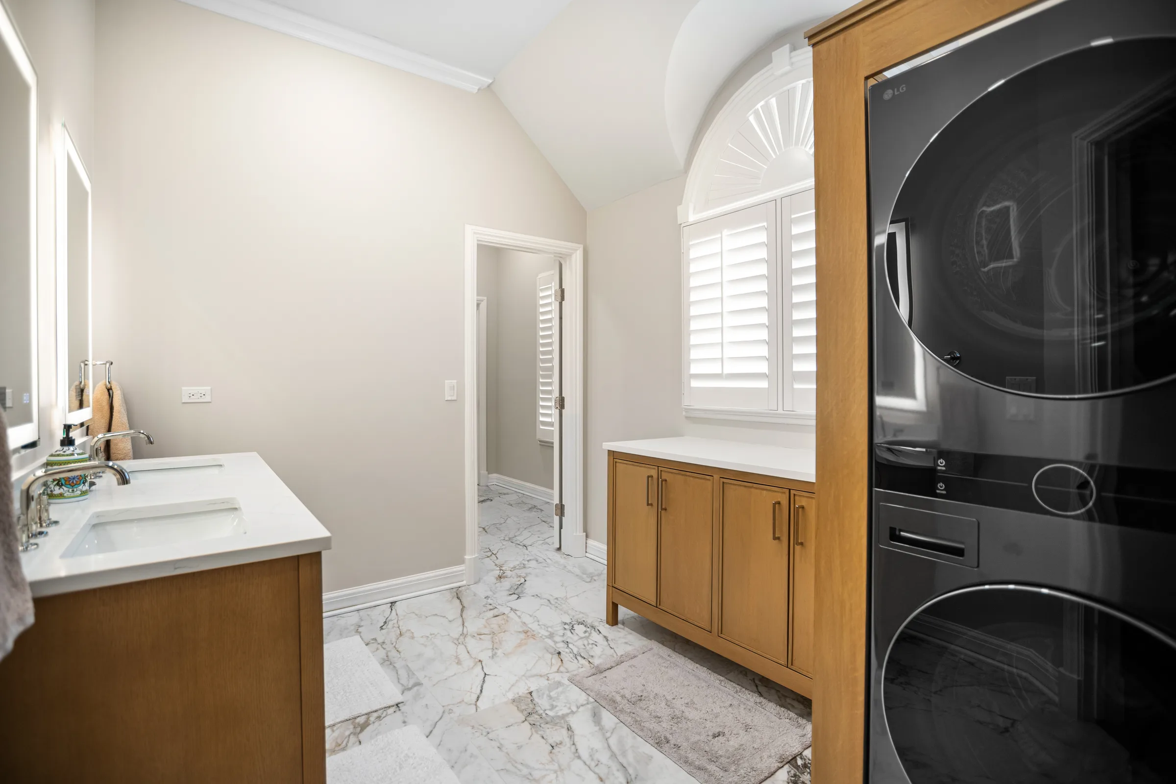 Lake Forest primary bathroom remodel: oak double vanity with marble countertop and backlit mirrors