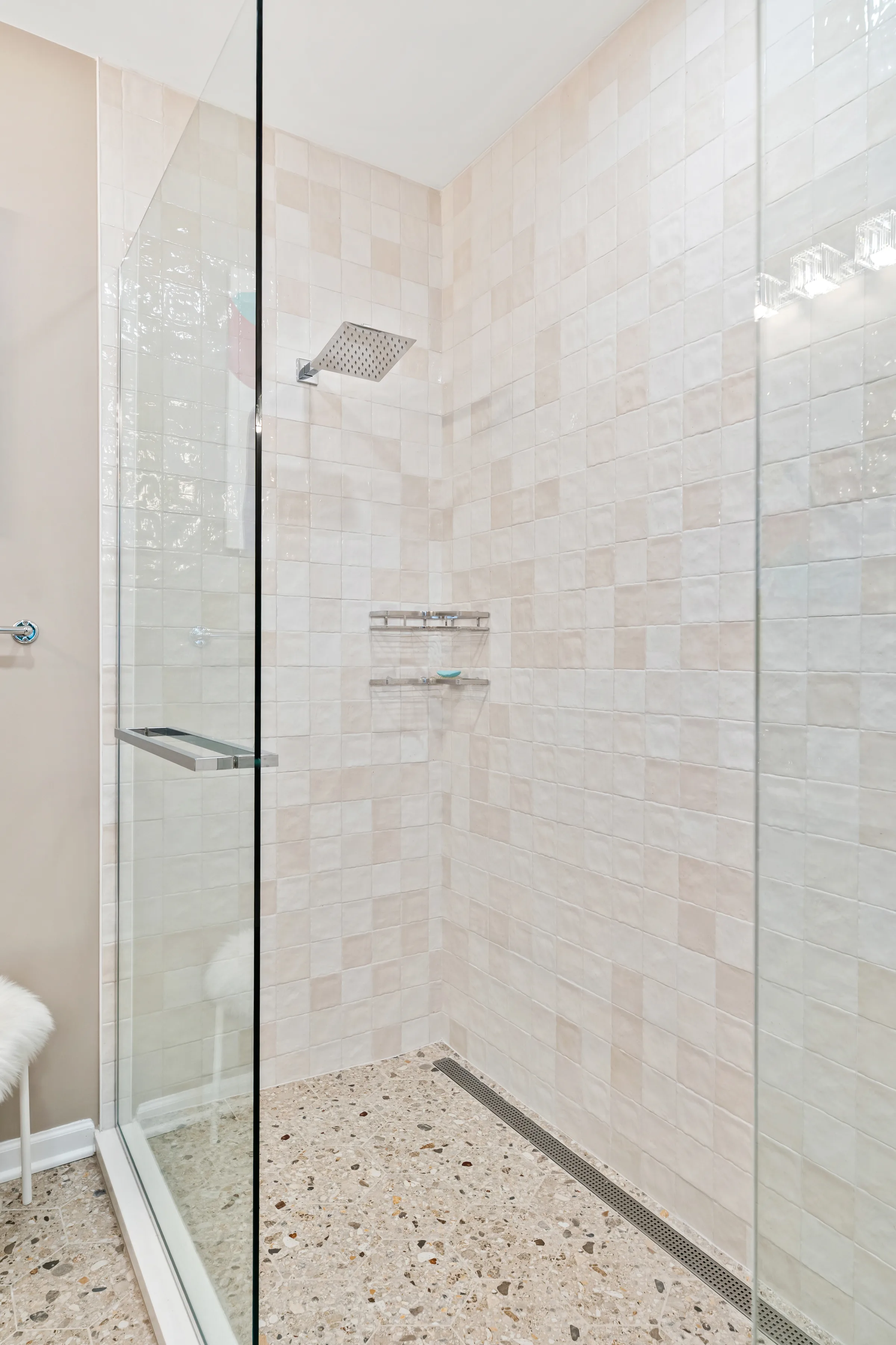 Northbrook bathroom remodel: gray shaker vanity, glass mosaic shower wall, and terrazzo-style flooring