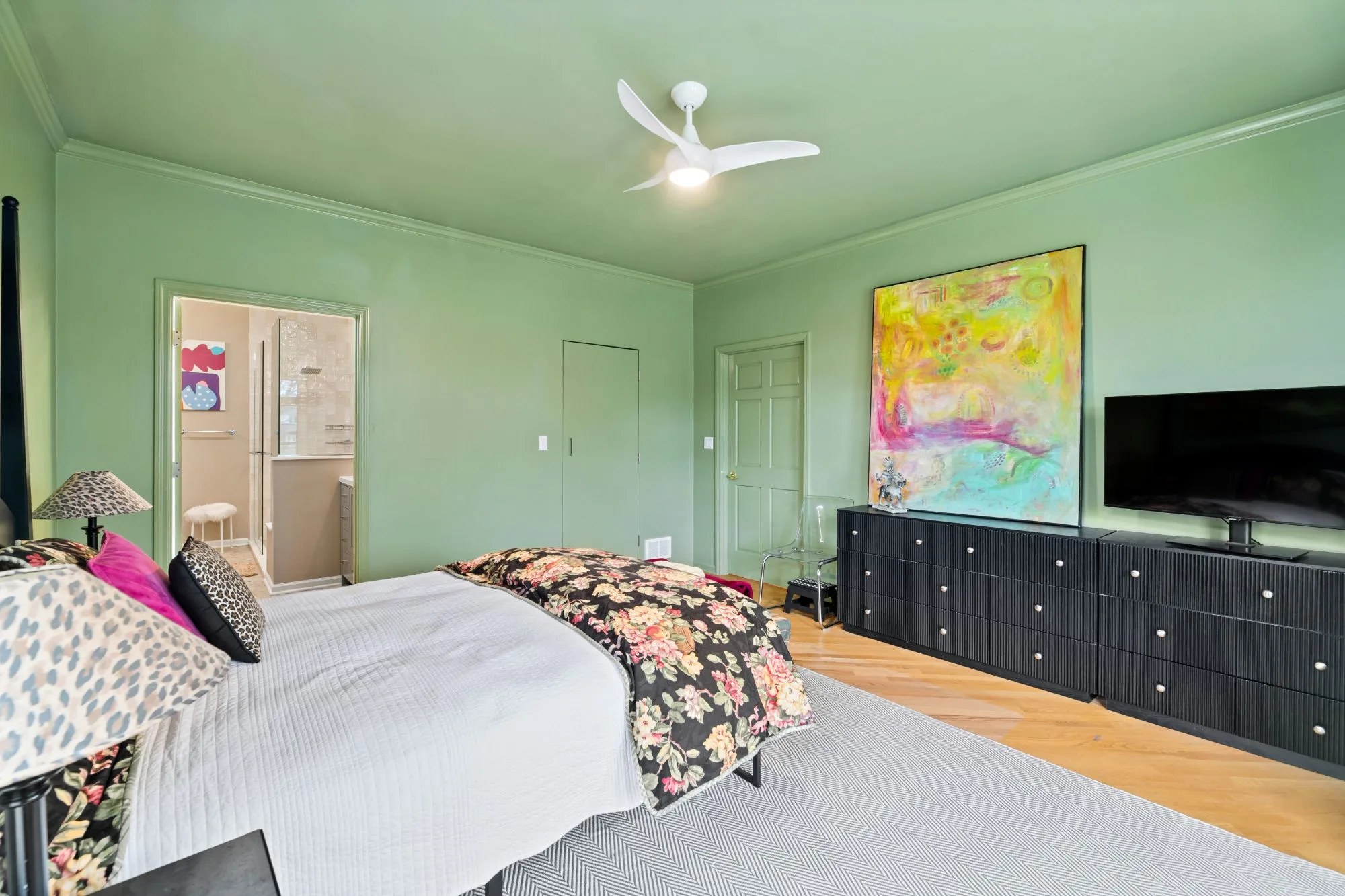 Primary bedroom with a doorway opening into the remodeled ensuite bathroom