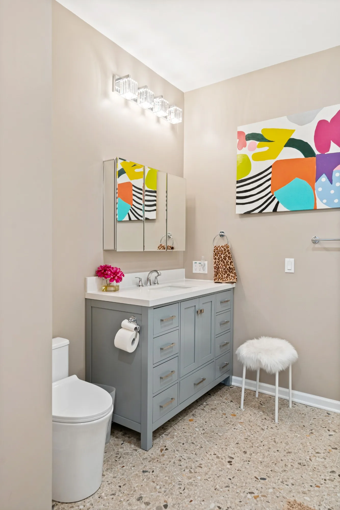 Gray Shaker vanity under a four-light crystal vanity fixture and mirrored cabinet