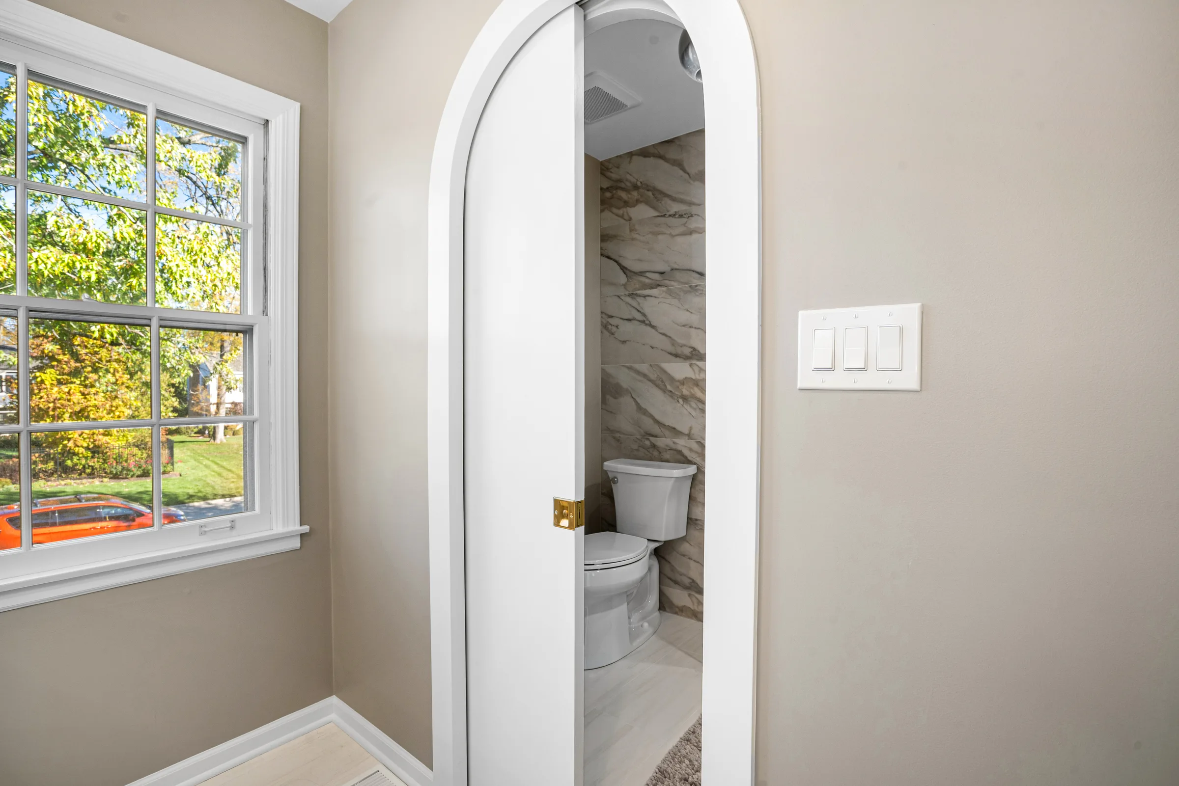 Lake Forest bathroom remodel: wide view of warm-wood double vanity and window wall